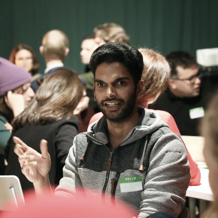 An Indian looking man taking part in a discussion round